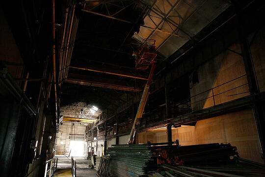A painter works on the ceiling of the future hot shop
