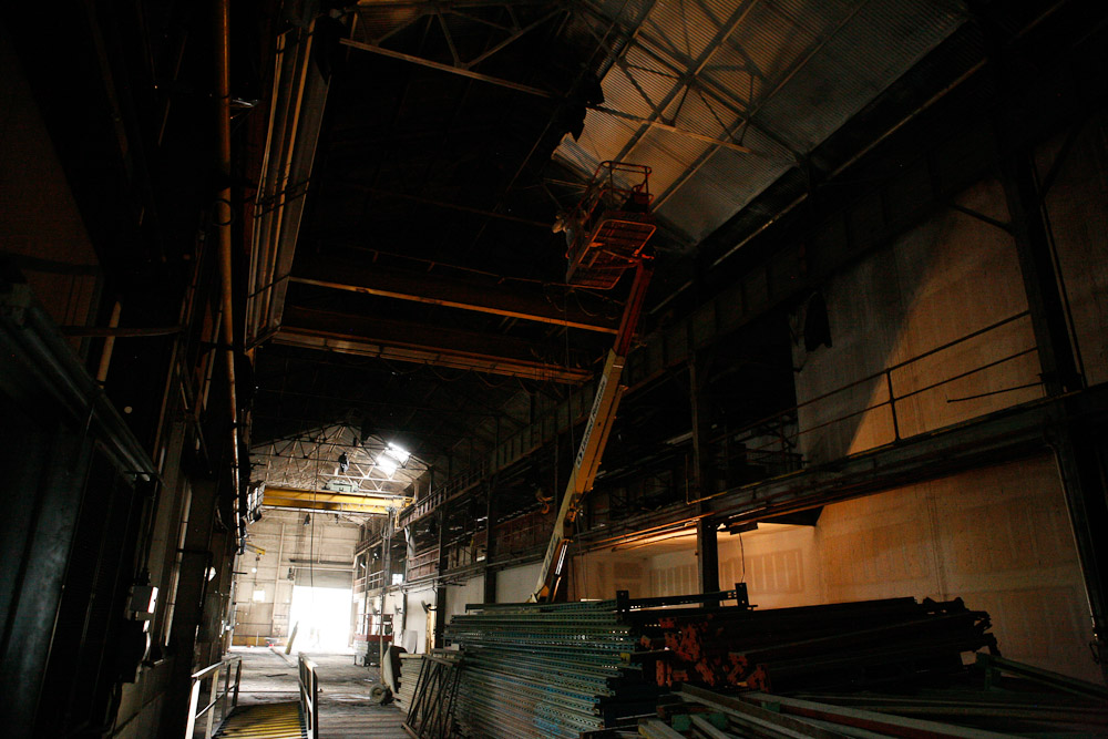 A painter works on the ceiling of the future hot shop