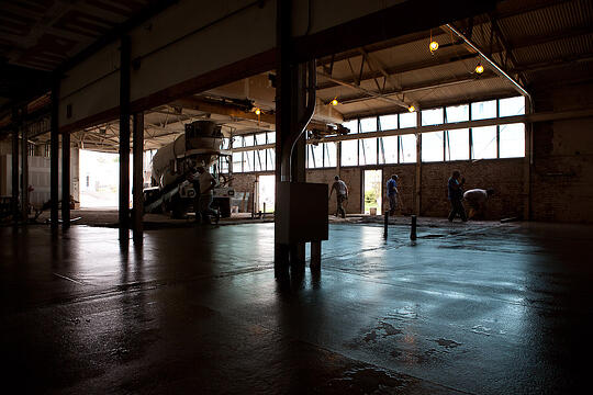 Reflections are seen on the surface of the newly finished concrete floor