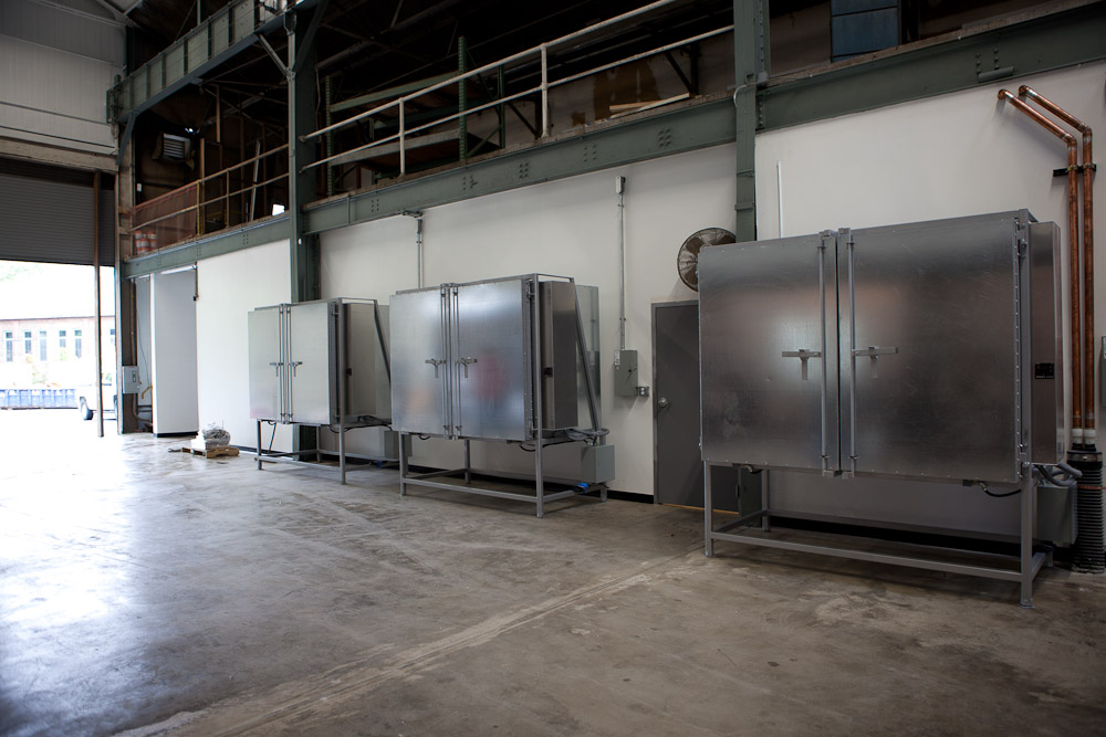 Three annealers are placed across the room from the glass furnace