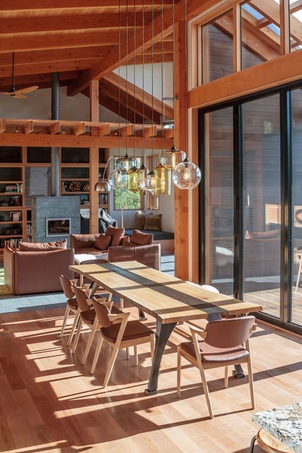 Timberidge home by 2form architecture with Niche handmade glass lighting pendants Effervescent Solitaire, Smoke Oculo, Amber Bella, Smoke Pharos, Amber Turret, Effervescent Minaret, and Grey Oculo hang above dining room table