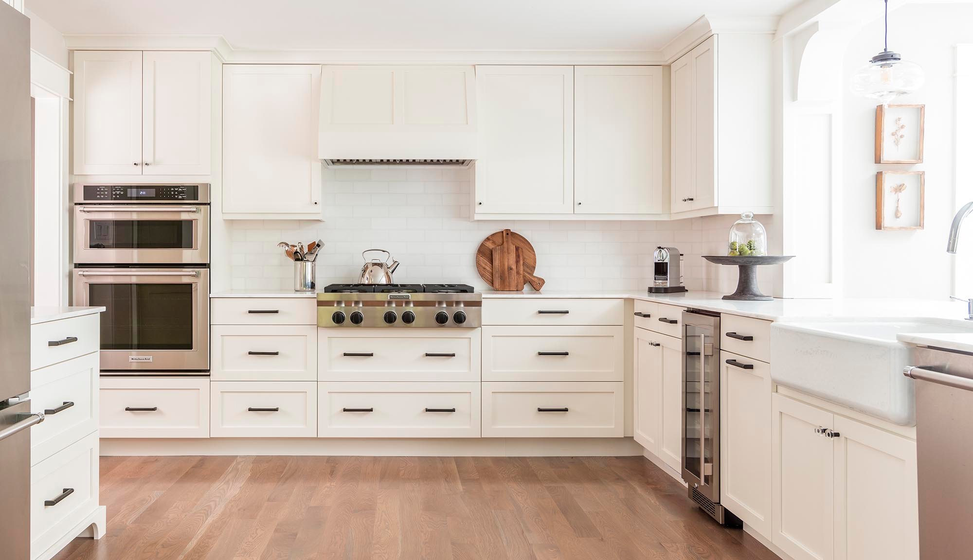 Clean White Kitchen Featuring Shaker Cabinets and Modern Glass Lighting